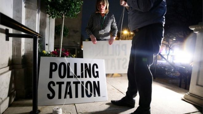 Workers prepare signs outside a polling station on general election day in London, Britain, December 12, 2019.