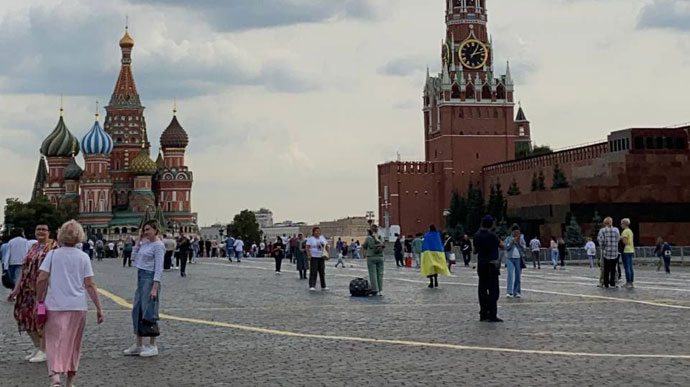 Woman wraps herself in Ukrainian flag on Red Square in Moscow 