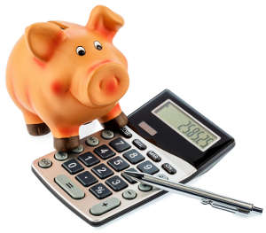 Red pen on a calculator beside a piggy bank - save on costs, expenses, and budget