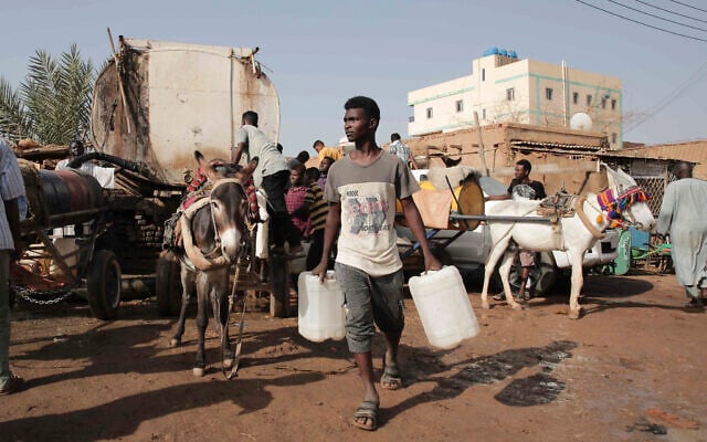 People gather to collect water in Khartoum, Sudan, May 28, 2023. (Marwan Ali/AP)