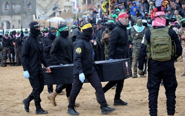 Palestinian terrorists carry to the Red Cross one of four coffins said to hold a body of a slain Israeli hostage, in the southern Gaza Strip's Khan Younis, February 20, 2025. (Eyad Baba / AFP) Palestinian terrorists carry to the Red Cross one of four coffins said to hold a body of a slain Israeli hostage, in the southern Gaza Strip's Khan Younis, February 20, 2025. (Eyad Baba / AFP)